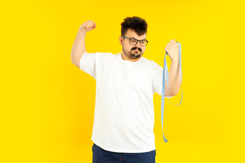 Man in Yellow Tshirt Holding Measuring Tape